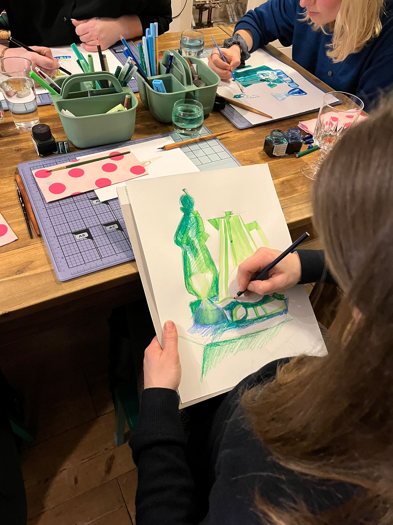 Deelnmers aan het werk met potlood, inkt en markers tijdens een kunstworkshop voor volwassenen in het atelier in Den Helder