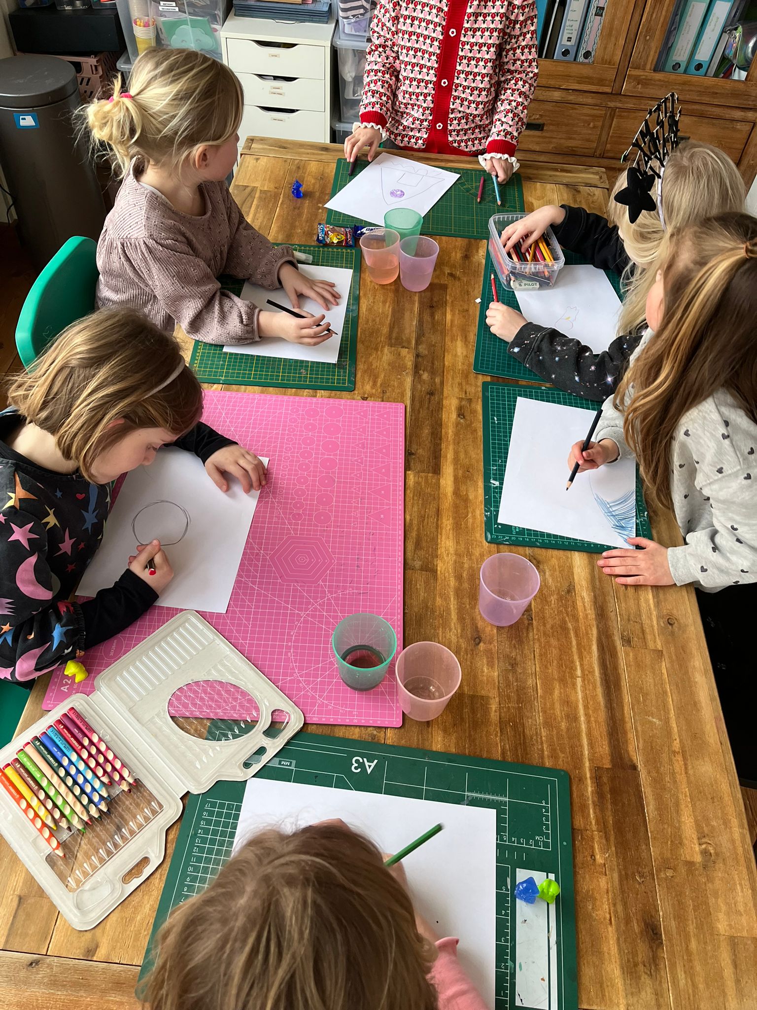 Kinderen werken geconcentreerd aan kleurrijke tekeningen tijdens een kinderworkshop in het creatieve atelier in Den Helder